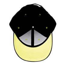 NIPPON DOKI STORE Jujutsu Kaisen black baseball cap with a contrasting yellow brim, top-down view.